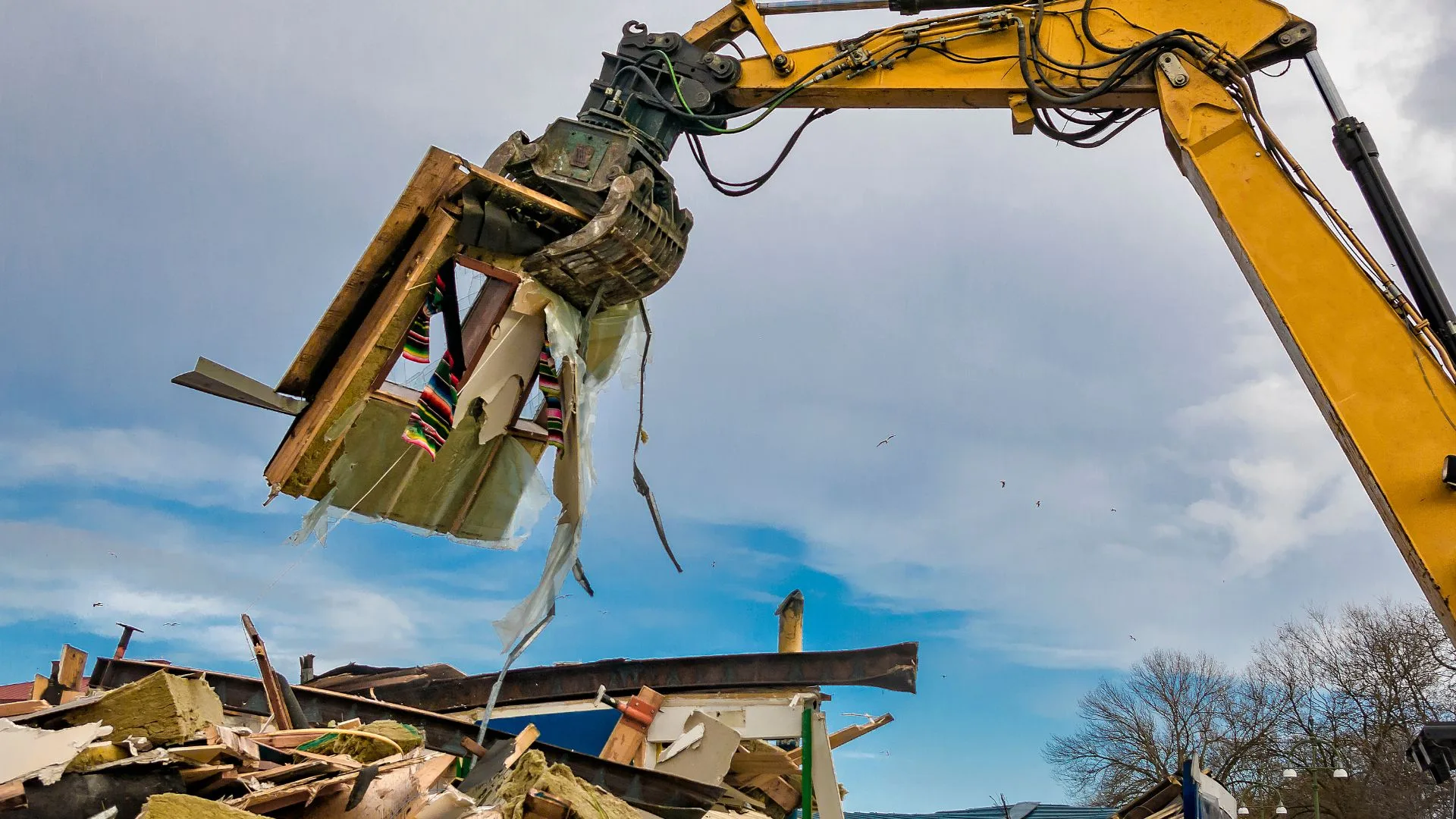 Excavator grapple sorting metal and concrete demolition debris