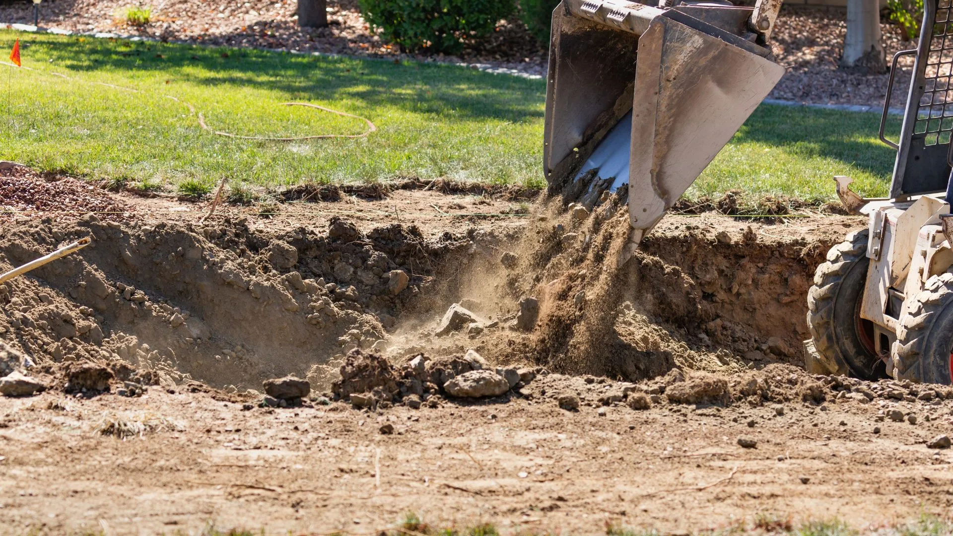 Excavator moving and shaping material during the rough grading phase