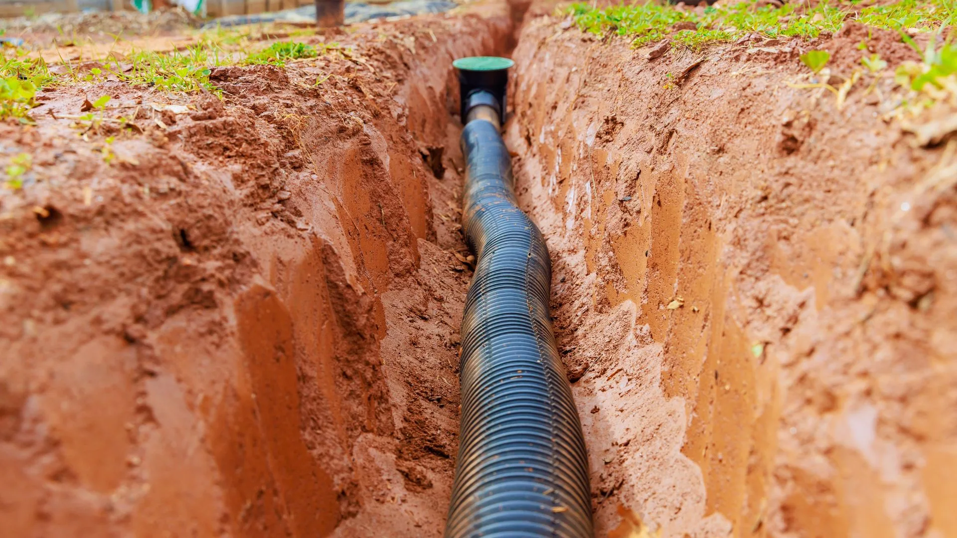 Open trench with newly installed drainage pipe on a Dillsburg property