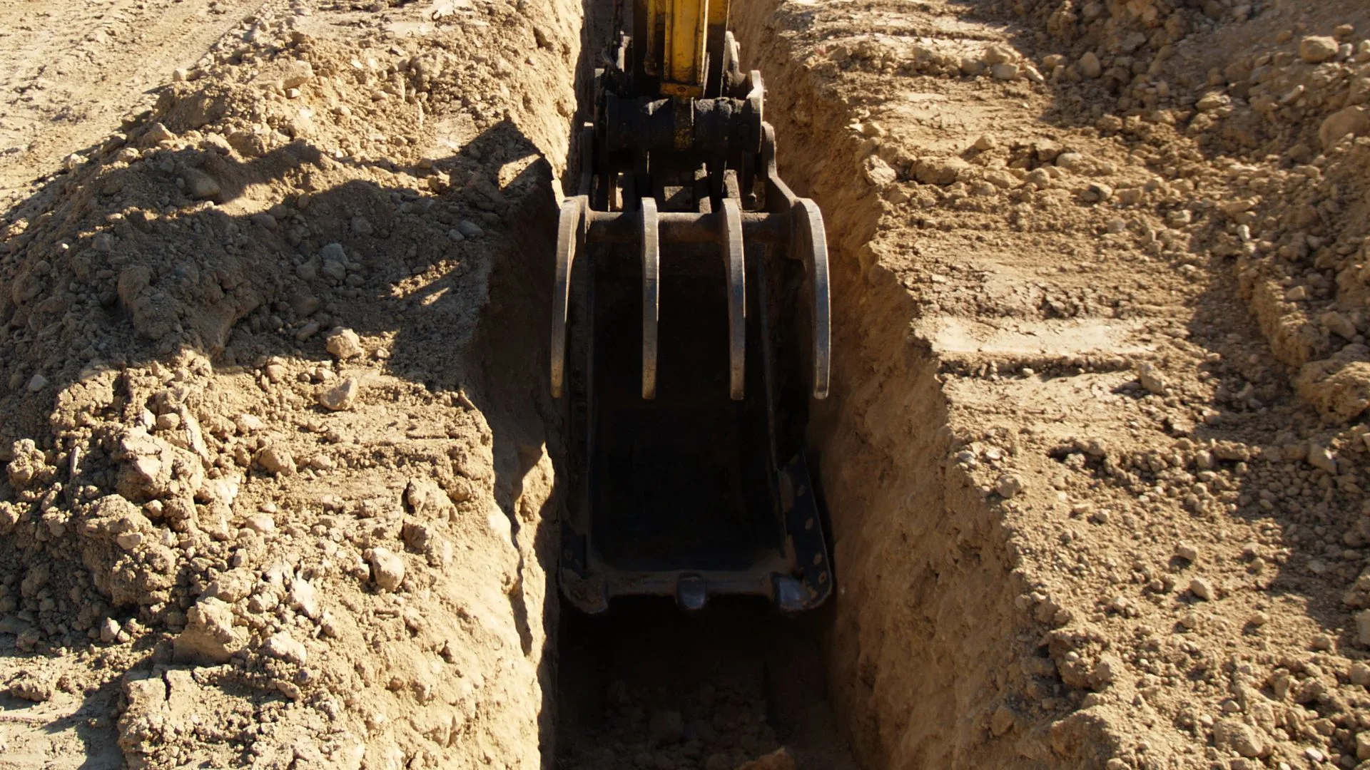 Aerial view of multiple parallel utility trenches cut on a construction site